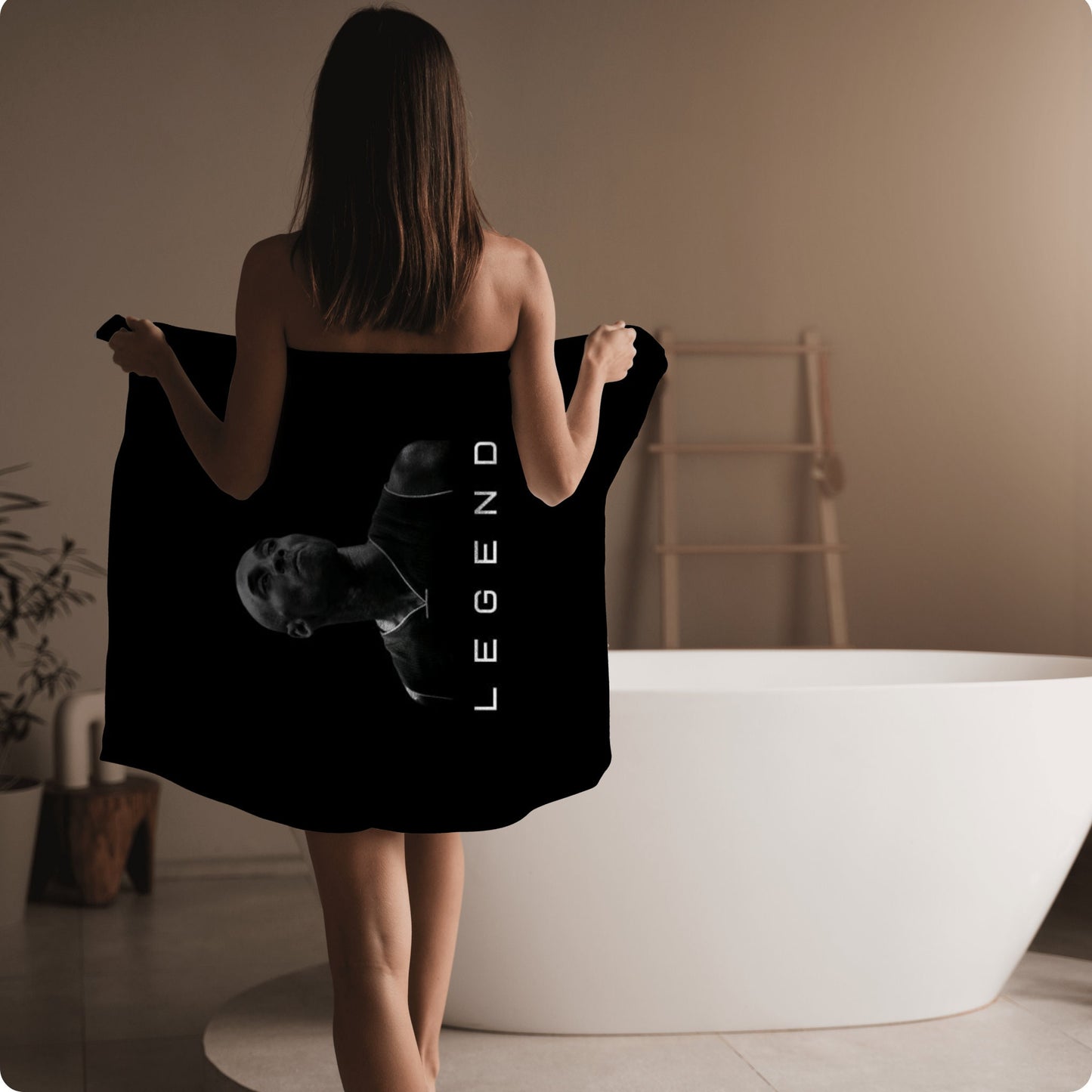 a woman in a black towel is walking towards a bathtub